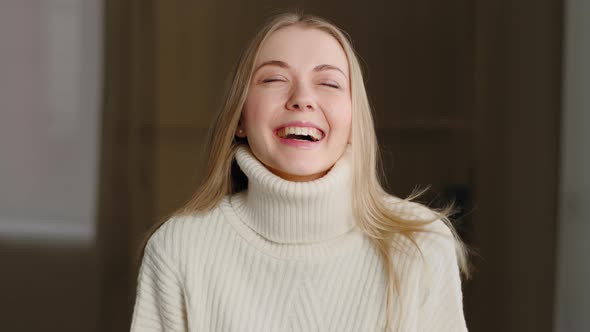 Portrait of Happy Beautiful Blonde Millennial Girl Standing Indoors Looking at Camera with White