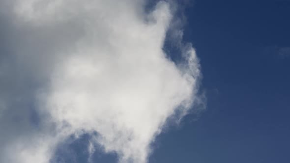 Fluffy White Clouds Moving Through Blue Sky