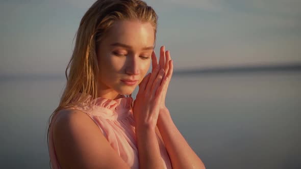 Young Tender Girl in the Water Against the Background of Dawn. Sexy Girl on the Beach. Young Woman