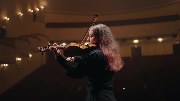 Portrait of Pretty Female Violin Player in Opera House Woman Violinist is Playing Fiddle in Music