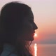 Profile of a young woman in front of the sunrise by the sea - VideoHive Item for Sale