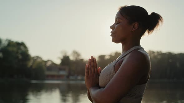 African American woman practicing breathing exercise at the park