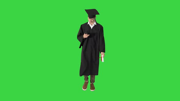 Young Graduate Student Using a Phone While Walking on a Green Screen, Chroma Key