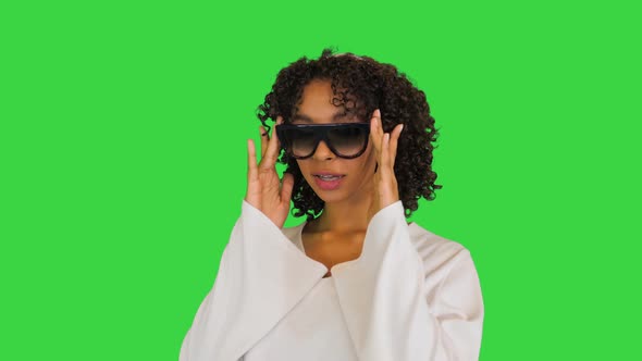 Beautiful African American Lady Smiles Looking Over Sunglasses on a Green Screen Chroma Key