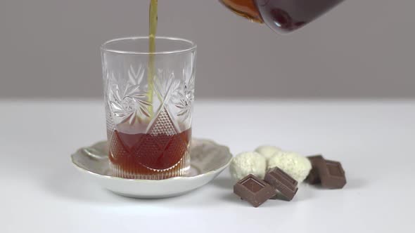 Tea Breakfeast With Chocolate And Pouring Tea Into A Cup