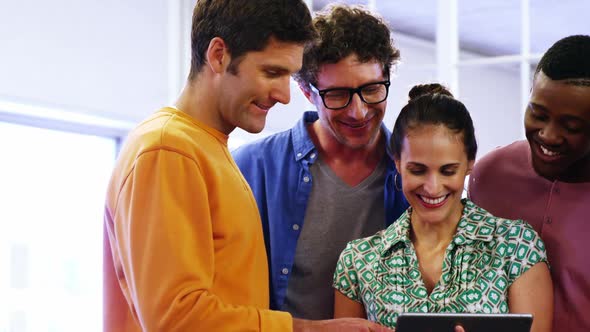 Group of business executives discussing over digital tablet