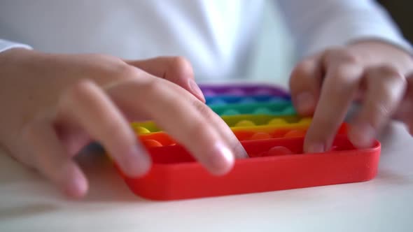 Girl Hands Close Up Playing with Rainbow Pop It Fidget