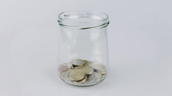 Coins stacking in glass jar