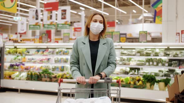 Portrait of Woman in Protective Medical Mask Walking in Supermarket with Trolley