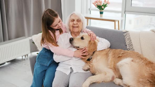 Grandmother and Granddaughter with Golden Retriever Dog