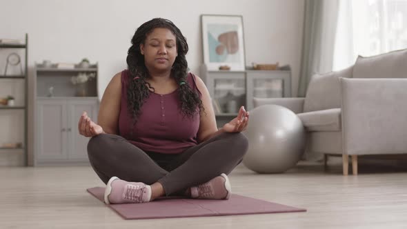 African-American Sporty Woman Meditating at Home