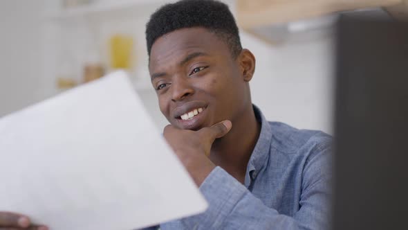 Closeup Portrait of Satisfied Young Handsome African American Man Analyzing Business Project Smiling