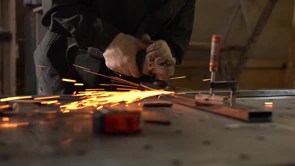 Male Worker Polishing Metal Part With Grinder