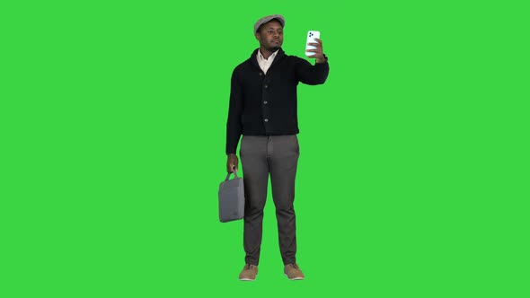 Casual African American Man with a Bag Taking a Selfie on a Green Screen Chroma Key