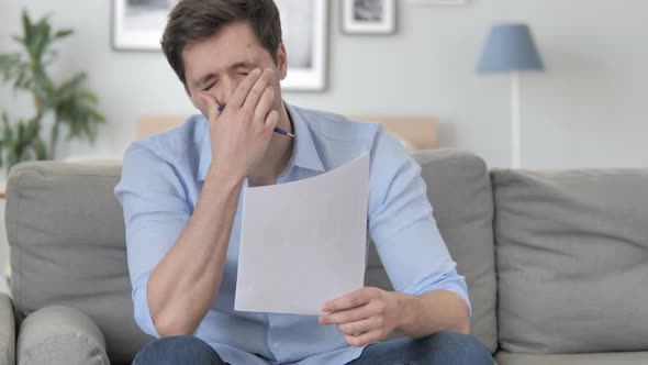 Man Feeling Upset while Reading Contract, Documents