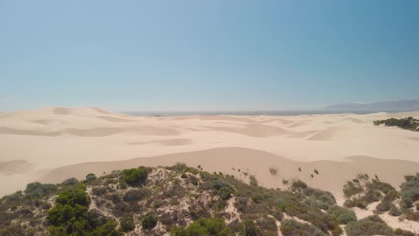 Drone flies over unique large sand dunes near Pismo Beach