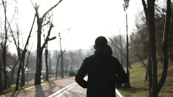 Backside Footage of Male Figure Running in Park