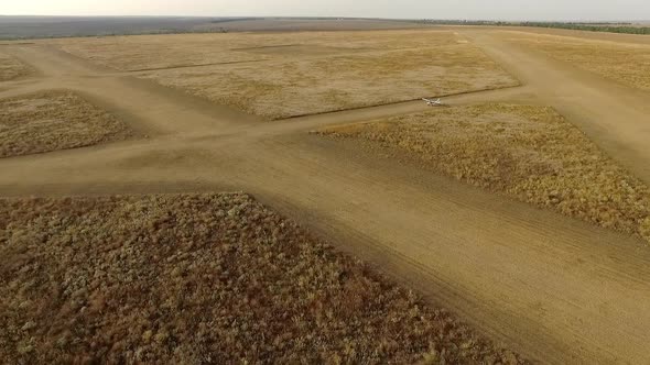 Footage From Drone in Slow Motion Small Airplane Taxiing Ready to Take Off on Runway in Yellow