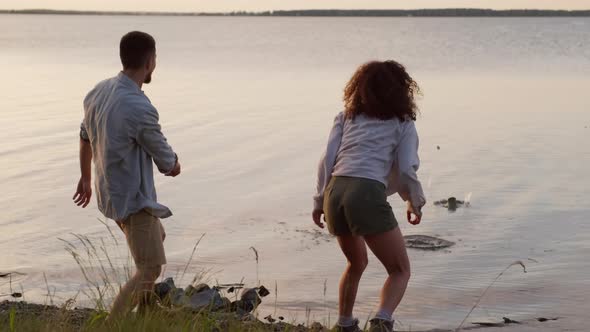 Man And Woman Skipping Pebbles