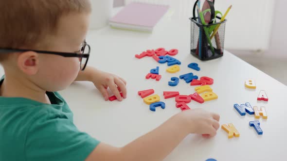 Cute Baby Child Kid Boy Making Words From Colorful Alphabetic Letters at Desk