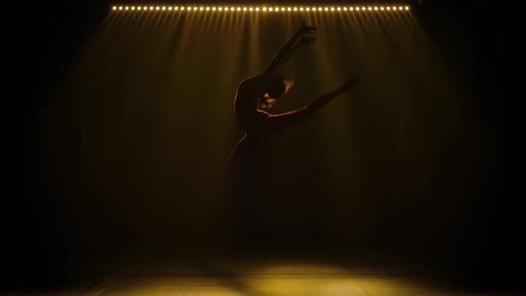 Silhouette of Sporty Young Women Practicing Acrobatic. A Girl Gymnast Doing Gymnastic Exercises