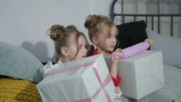 Happy American family celebrating Christmas. Children open a gift at home.