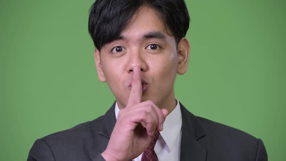 Young Handsome Asian Businessman with Finger on Lips