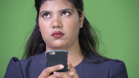 Young Overweight Beautiful Indian Businesswoman Against Green Background