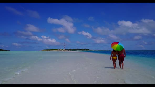 Man and lady posing on paradise tourist beach adventure by blue green ocean with white sandy backgro