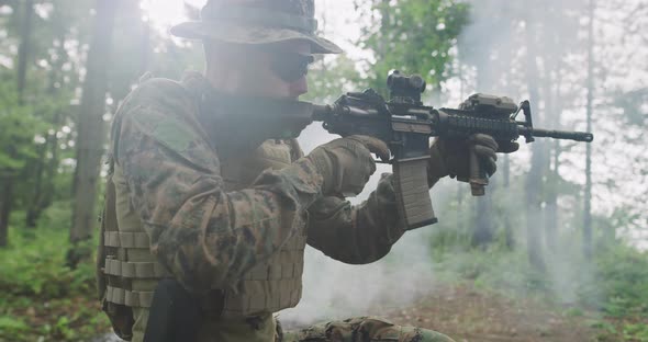 Soldier Taking Aim From Rifle in Forest Smoke in Background Military and Army Concept