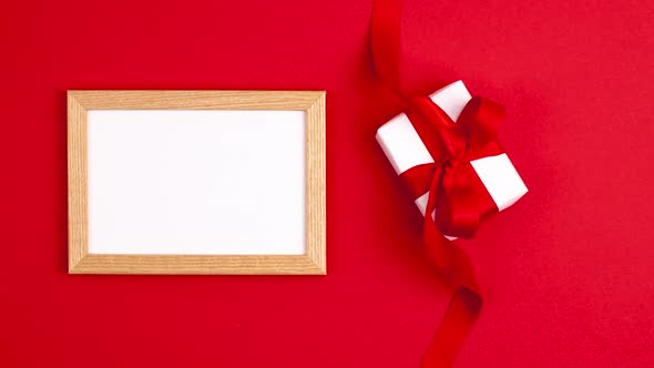 Stop motion animation of mockup white frame flat lay of white gift box with a red satin ribbon bow