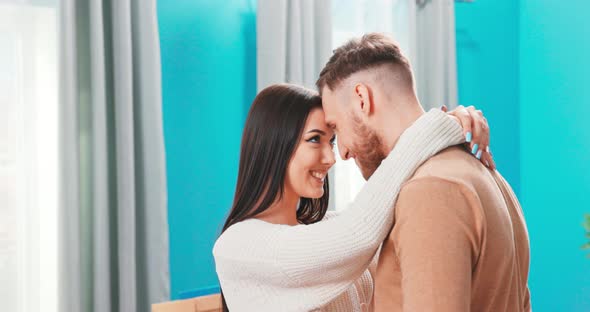 Smiling Millennial Man and Woman Touch Foreheads Hug Spend Romantic Intimate Tender Weekend at Home