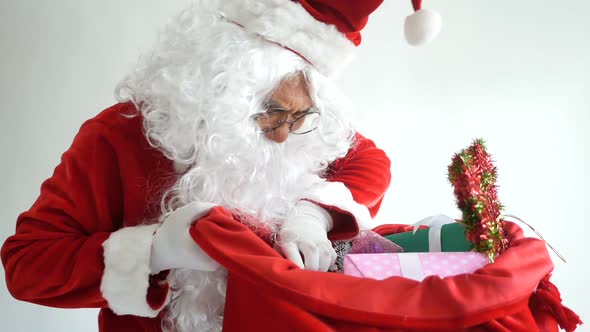 Cheerful funny Santa Claus touching beard looking at camera