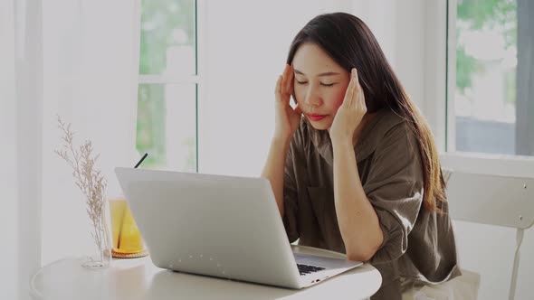 Tired and stressed young Asian woman feel pain eyestrain and rubbing her eyes