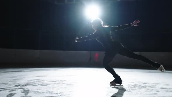 Single Woman Figure Skating Lady is Training Alone on Empty Ice Rink Performing Elements and
