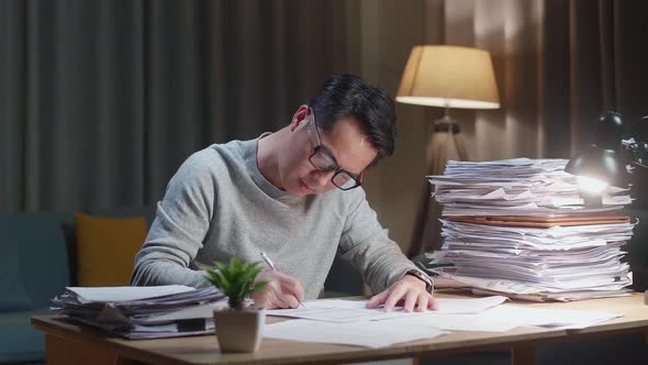 Asian Man Working With Documents At The Home