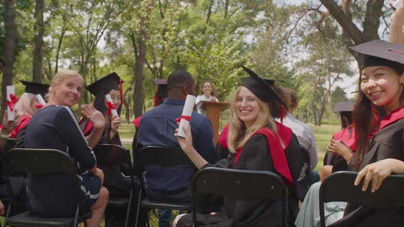 Joyful Successful Diverse Multiethnic Graduates in Academic Dresses Showing Diplomas