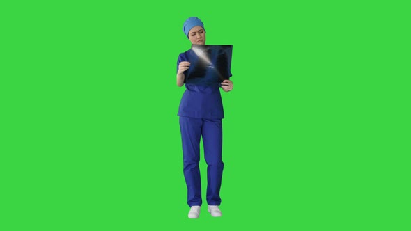 Thinking Female Doctor in Uniform Examining a Chest Xray on a Green Screen Chroma Key