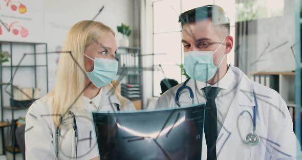 Doctors in Protective Masks Discussing Results of Scull Scan