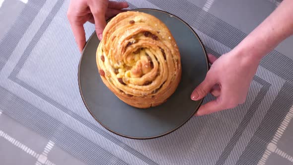 Young Woman Puts Fresh Baked Easter Cake Cruffin on Kitchen Table
