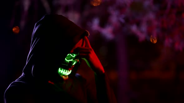 Scary Suit for Halloween Party Man in Hoodie and Glowing Skull Mask Enigmatic and Mysterious Image