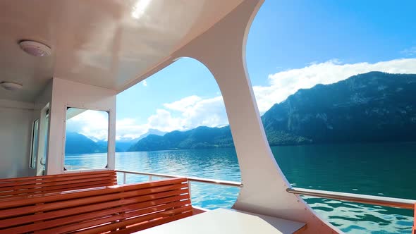 Point of view of a yacht boat sailing in scenic sea lake with the mountains as  background during a