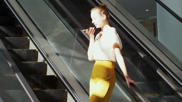 Young businesswoman on an escalator in a modern building