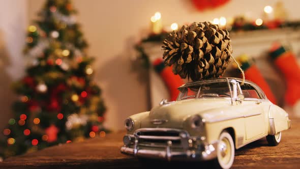 Toy car with pine cone on wooden table