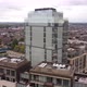 Drone Footage of a Glass Skyscraper Surrounded By Apartment Buildings - VideoHive Item for Sale