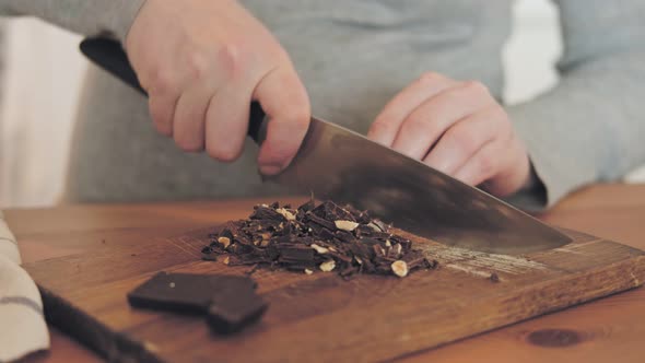 Pregnant woman cutting chocolate with nuts