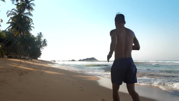 Strong Athlete Runs Along Yellow Sandy Beach Slow Motion