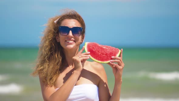 Smiling Woman Eating Watermelon on Beach