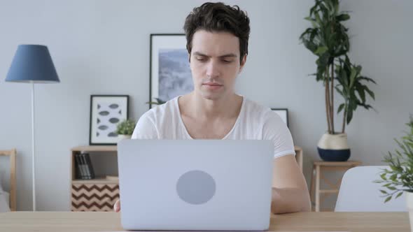 Young Casual Man Working On Laptop in Creative Office