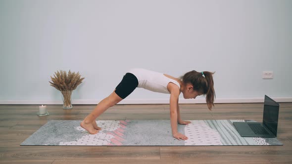 Caucasian Girl Does Yoga Child Performs Exercises on the Gymnastic Exercises Online Yoga for